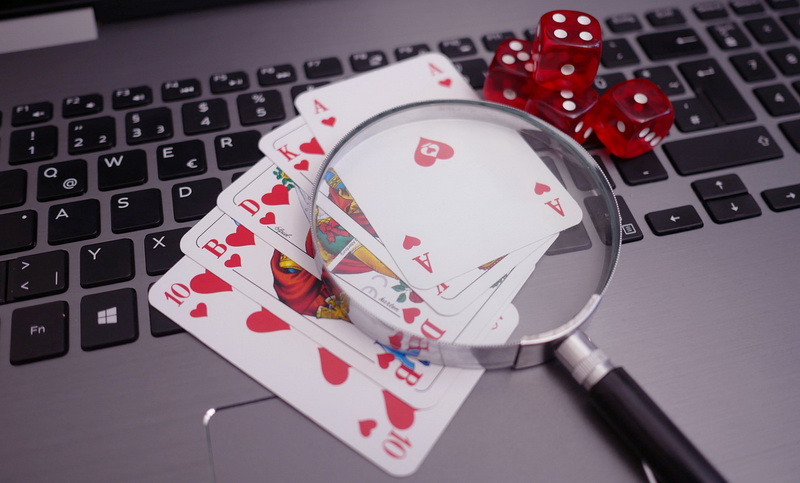 Kortų kombinacija, kauliukai ir lupa - internetinis pokeris internete